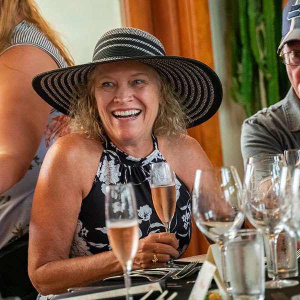 Smiling woman in hat holding champagne glass