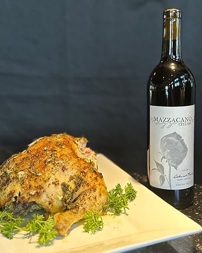 Roast chicken with red wine on the table.