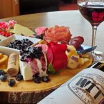 Cheese platter with wine and crackers on table.