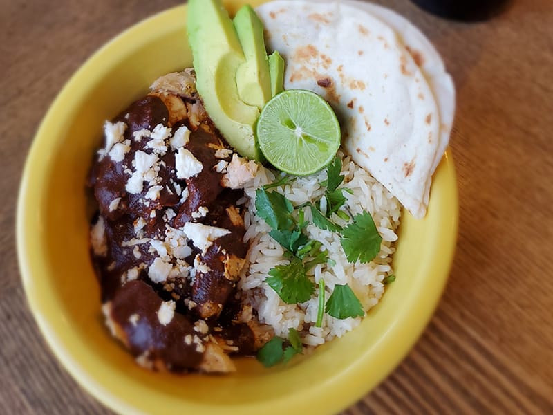 Mexican rice bowl with mole chicken and avocado
