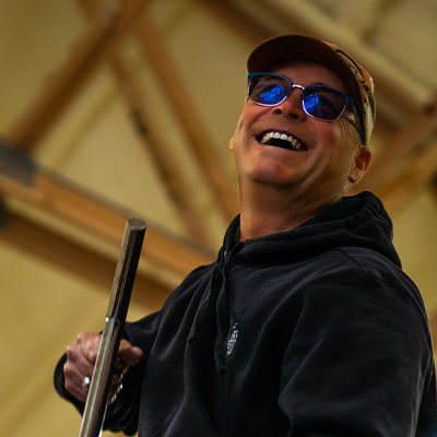 Smiling man with sunglasses holding a broom.