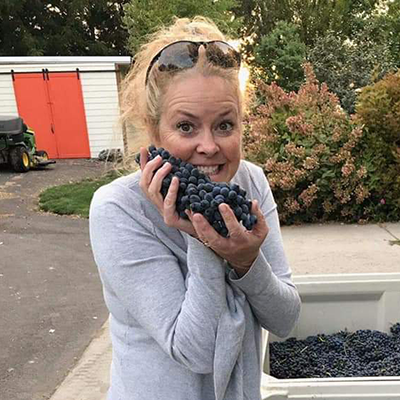 Woman excitedly holding grapes outdoors