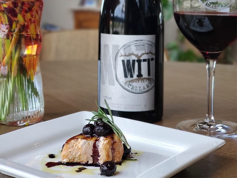 Gourmet salmon dish with red wine pairing.