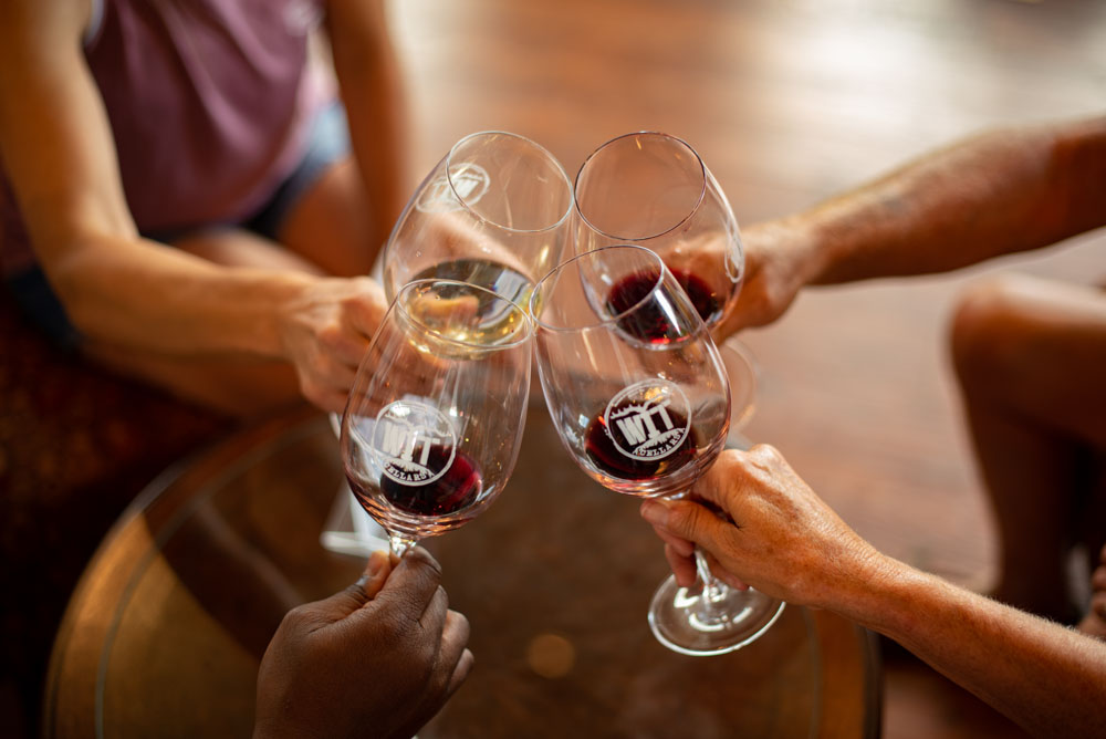 WIT Cellars-9583 Four wine glasses clinking in celebration.