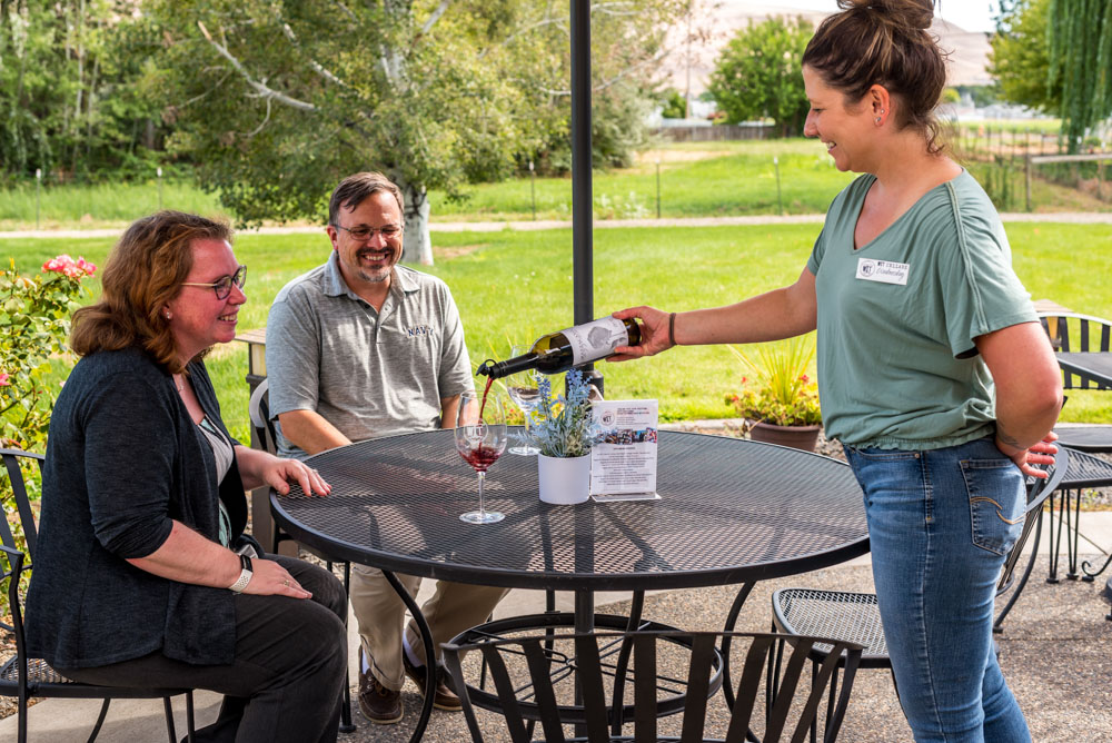 WIT Cellars-9629 Server pouring wine for outdoor diners.