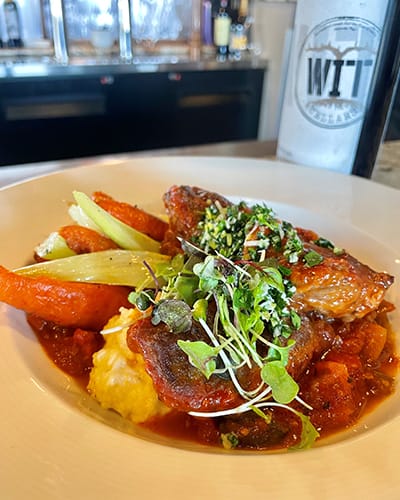 Gourmet chicken dish with vegetables and sauce.