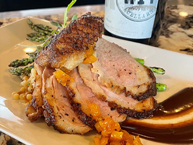 Roasted duck breast with sauce and asparagus.