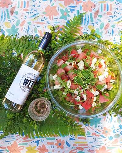 watermelon-salad-2020-Rose Refreshing salad with wine bottle on colorful table.
