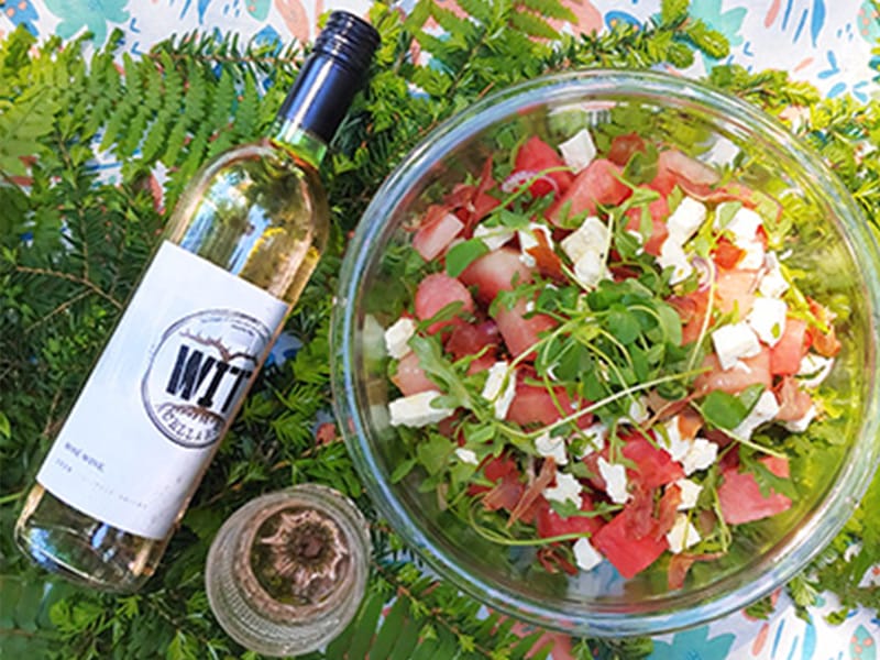 Watermelon feta salad with wine on table.