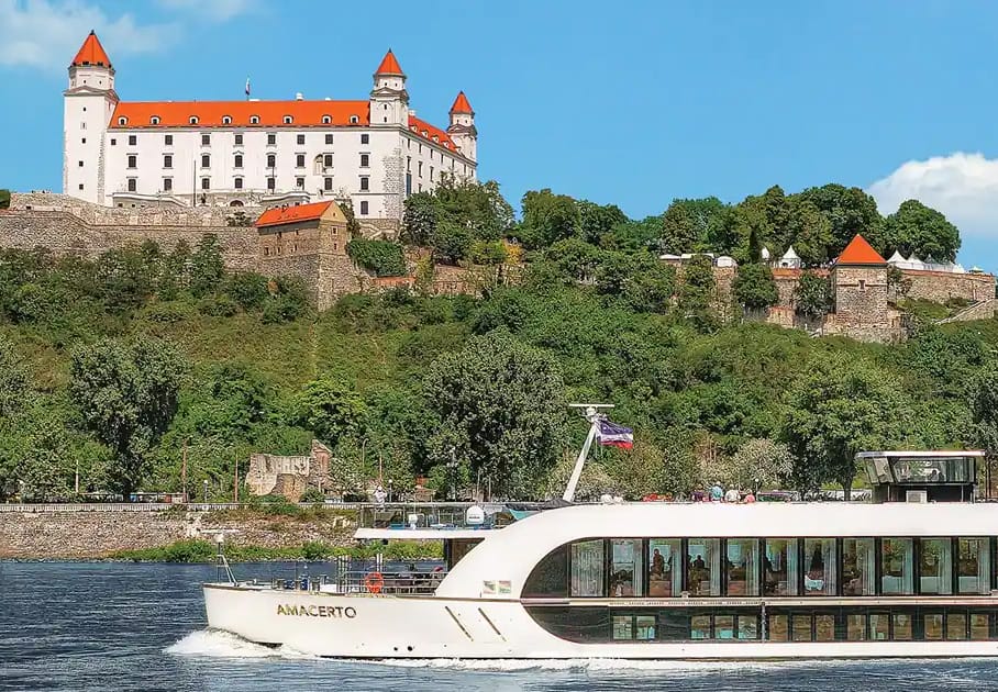 Historic castle above river cruise ship in Bratislava.