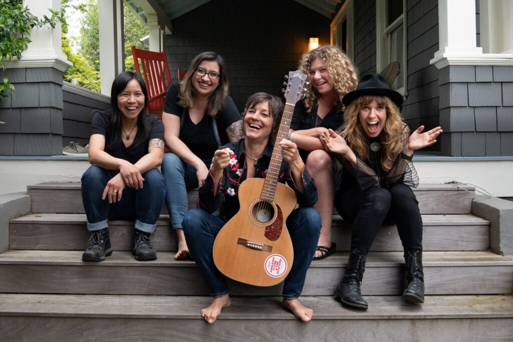 Ashleigh-Flynn Five women sitting on porch steps, smiling.