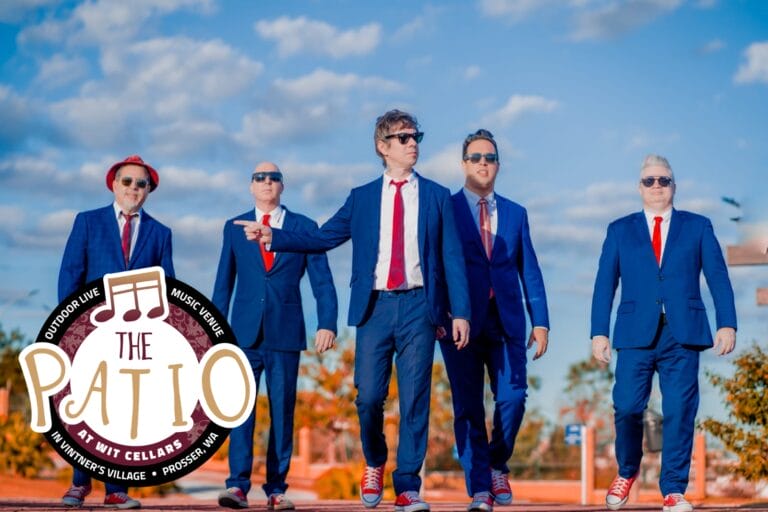 Band in blue suits outdoors with logo.