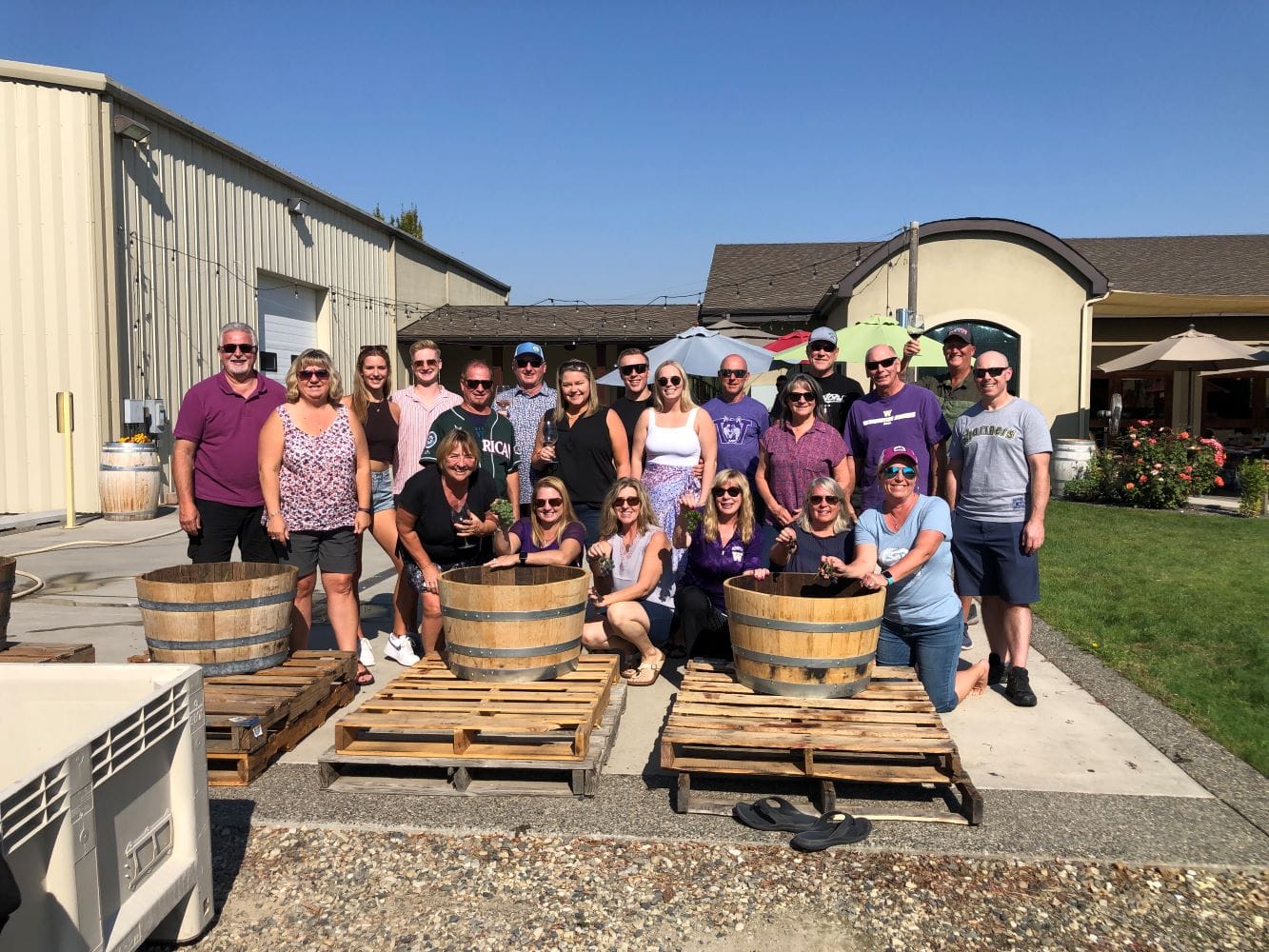 Group enjoying outdoor winery barrel event.