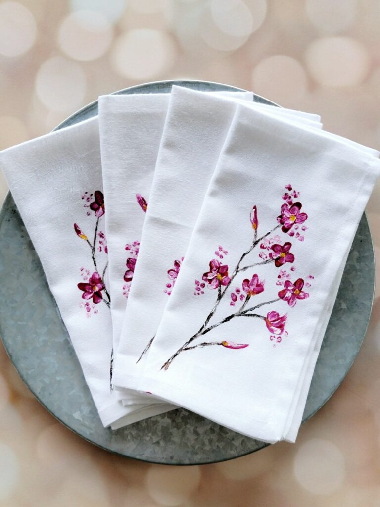White napkins with pink floral design on plate.
