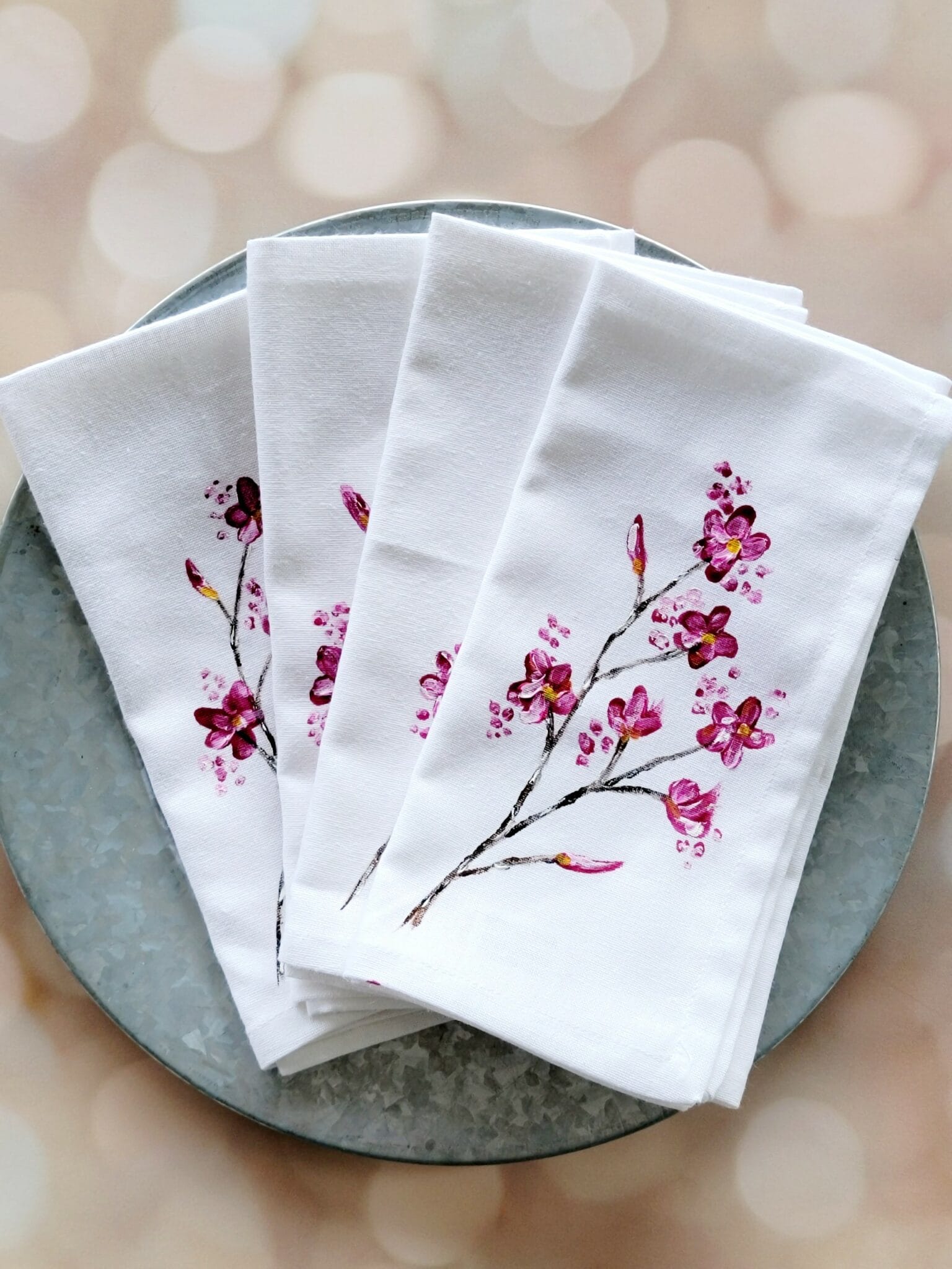 White napkins with pink floral design on plate.