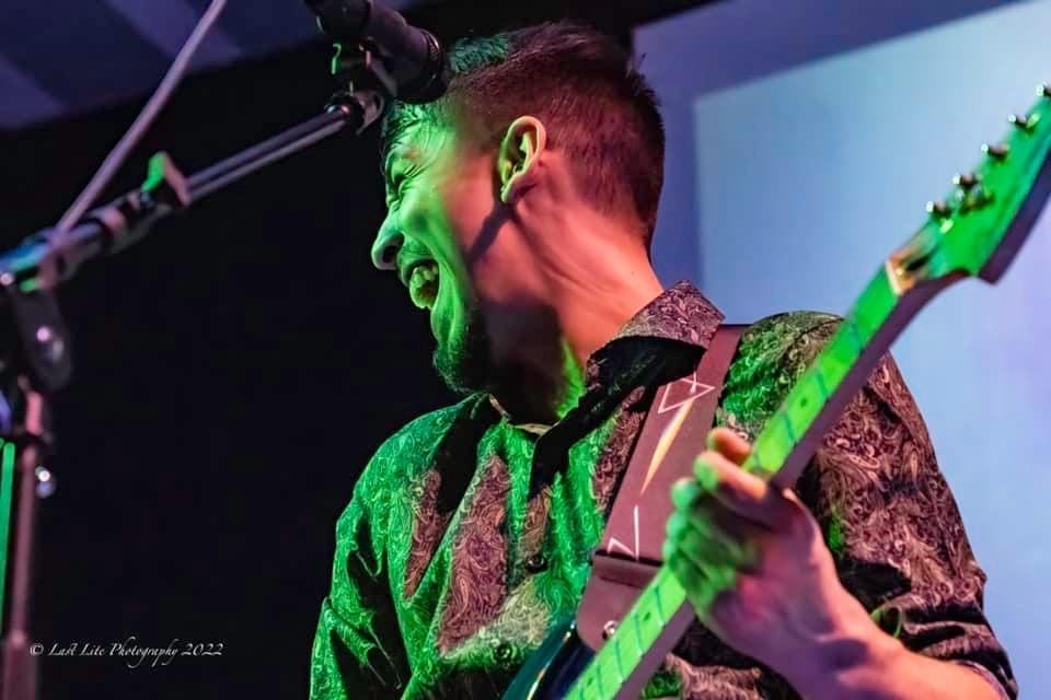 Guitarist energetically performing on stage