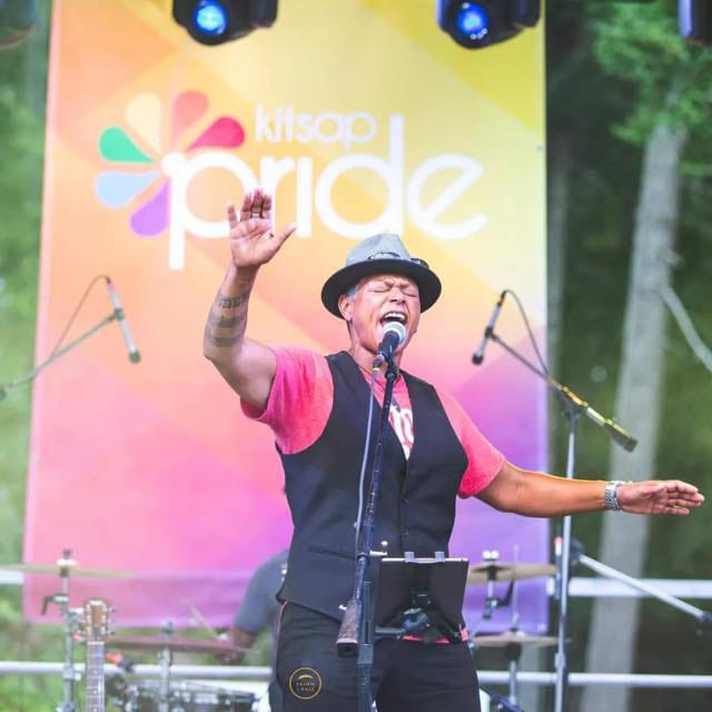 Performer singing on stage at Kitsap Pride festival.