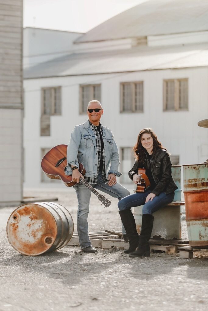 Two musicians with guitars outdoors