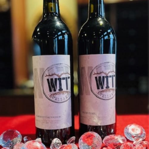 Two WIT Cellars wine bottles on ice display.
