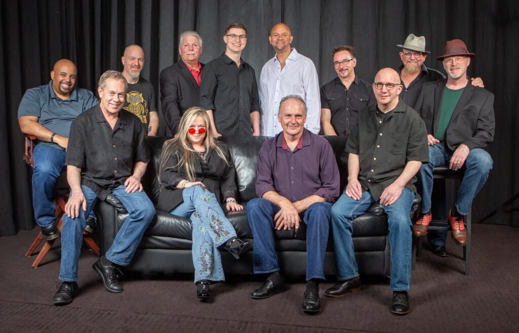 Group of musicians posing together on couch.