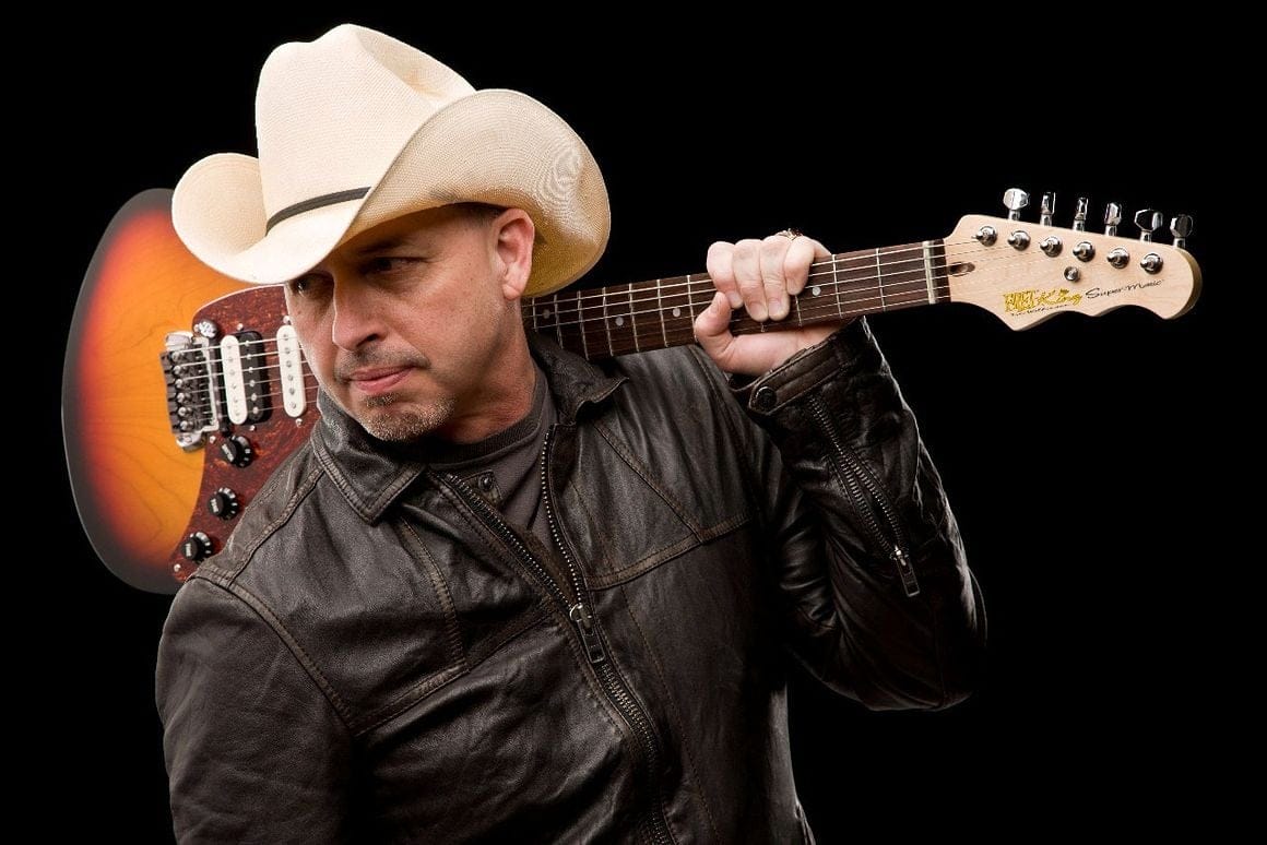 Man in cowboy hat holding electric guitar