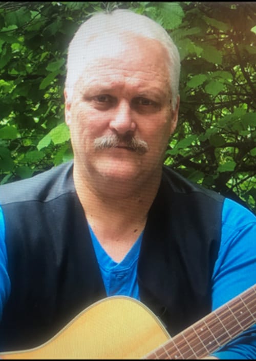 steve-olsen Man with guitar outdoors.