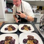 Chef presenting gourmet dishes in kitchen