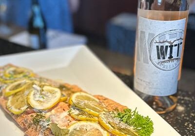 Lemon herb salmon with wine on table