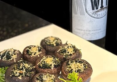 Stuffed mushrooms with wine on a white plate.
