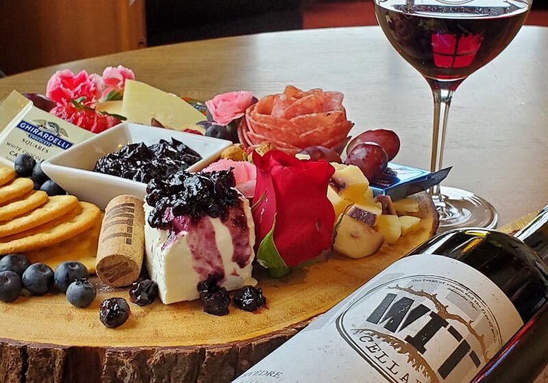 Cheese platter with wine and crackers on table.