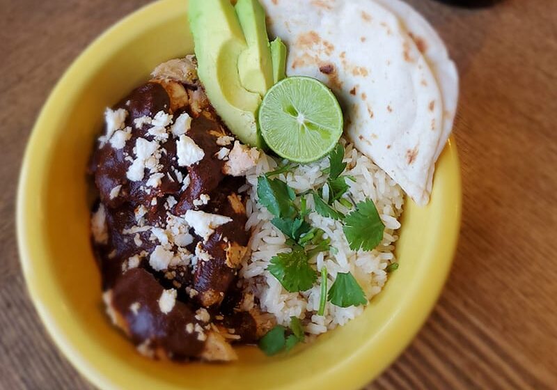 Mexican rice bowl with mole chicken and avocado