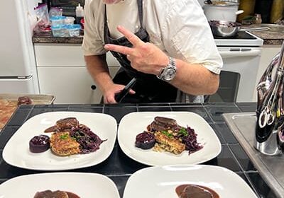 Chef presenting gourmet dishes in kitchen