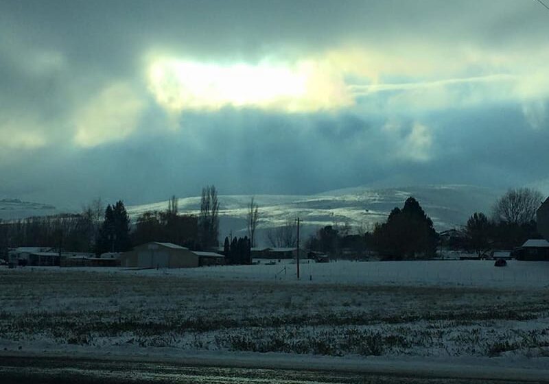 Snowy landscape with cloudy sky and sunlight.