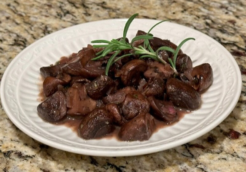 Sautéed mushrooms with rosemary on white plate
