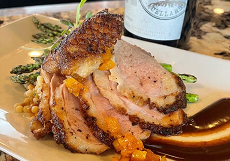 Roasted duck breast with sauce and asparagus.