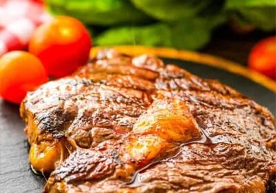 Juicy grilled steak with fresh vegetables on plate.