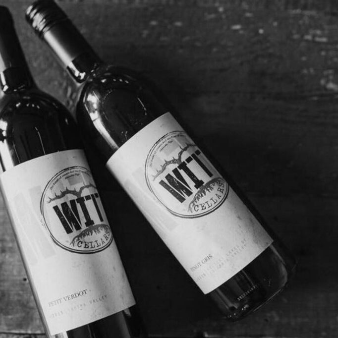 Two bottles of wine on wooden surface.