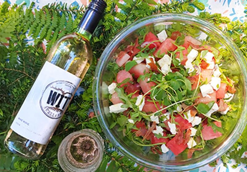 Watermelon feta salad with wine on table.